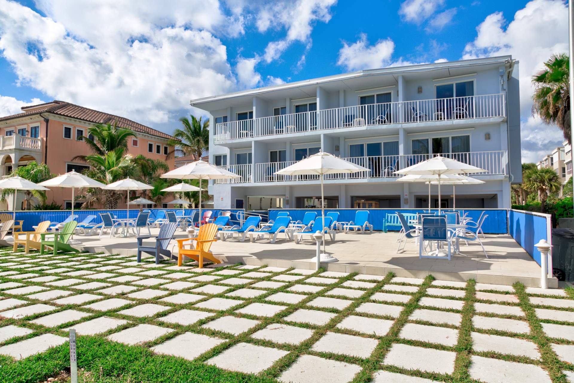 Back of the hotel with lawn chairs and umbrellas