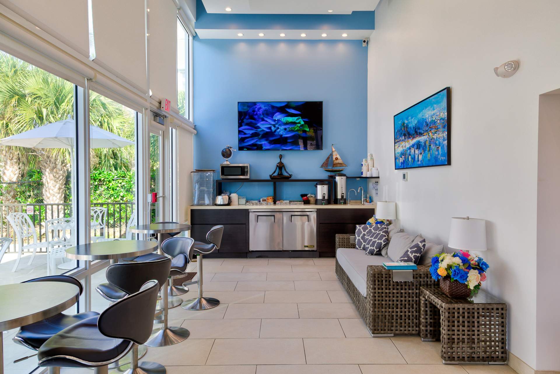 View of lobby with two TVs, a couch, tables and chairs